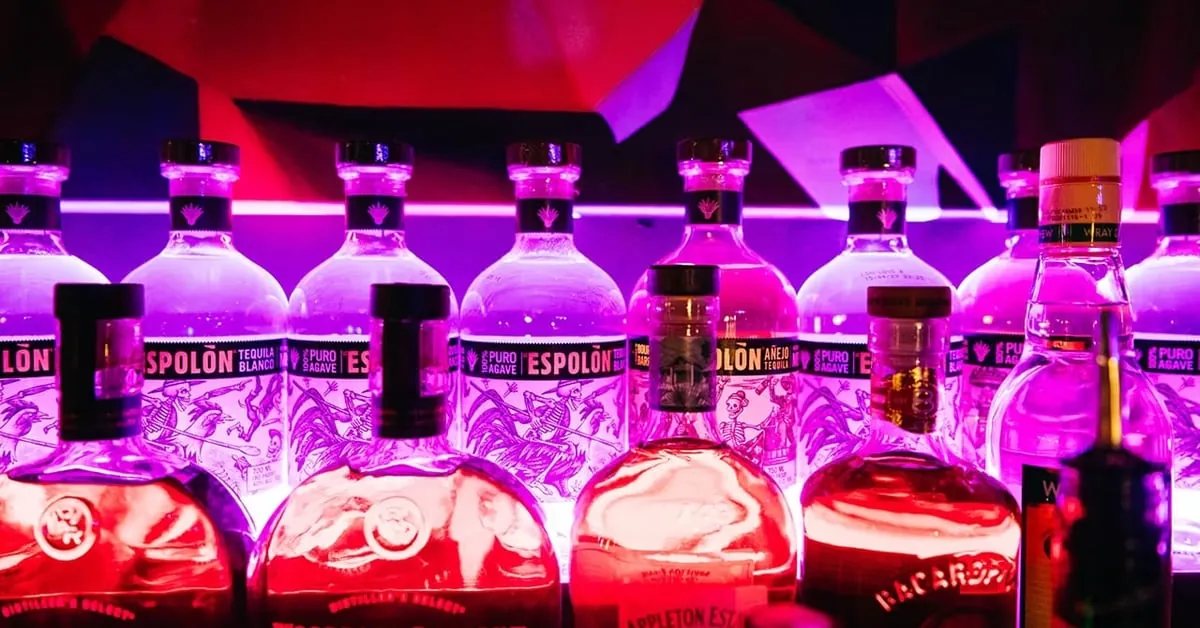 Bottiglie di Espolón Tequila in fila dietro al bancone, sotto luci viola