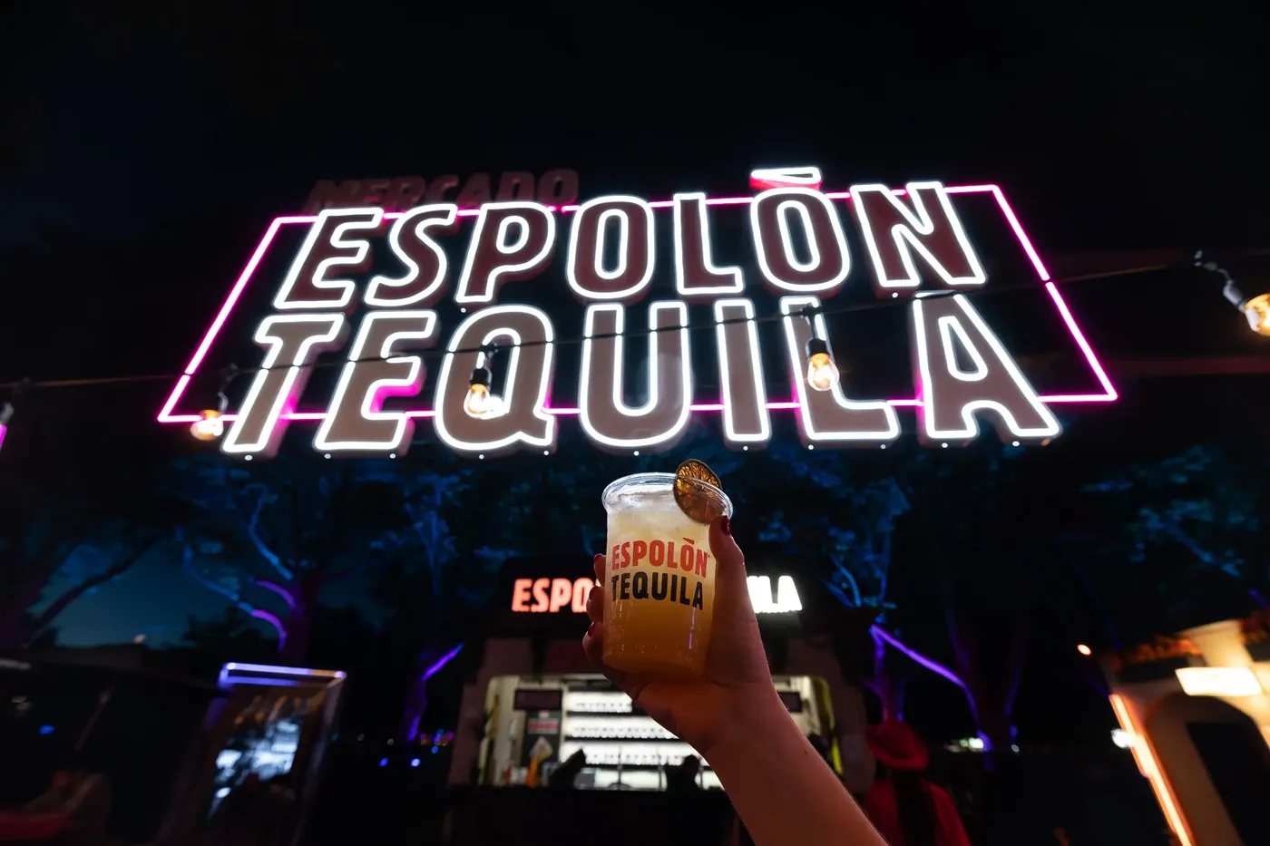 L'insegna al neon di El Mercado Espolón Tequila, con un cocktail Paloma in primo piano