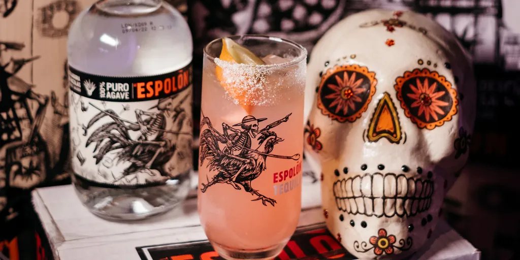 Bottiglia di Espolón Tequila, un cocktail Paloma e un teschio decorativo, still life a tema El Mercado